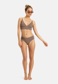Ensemble de bikini deux pièces marron, comprenant un haut bralette triangulaire avec de fines bretelles et un bas taille haute. Texture lisse et design minimal.