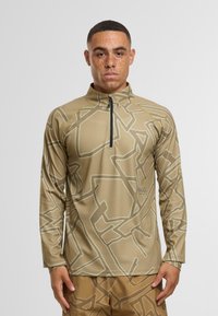 Beige Langarm-Zip-Up-Oberteil mit geometrischem Muster in Hellgrau, aus einem strukturierten Stoff gefertigt, mit Stehkragen und Logo-Details.
