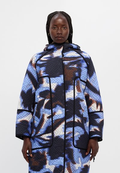 Πουφ jacket με ραφές σε μπλε και μαύρο χρώμα, διακοσμημένο με σπειροειδές αφηρημ�ένο σχέδιο. Διαθέτει κουκούλα, μπροστινό κλείσιμο με φερμουάρ και πλαϊνές τσέπες με αντίθετους ραφές.