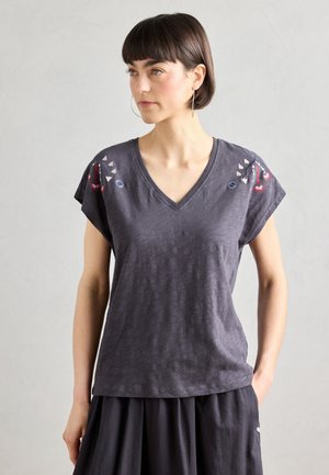 Gray V-neck t-shirt made of lightweight fabric. Features embroidered accents in red, blue, and white on shoulders. Short sleeves.