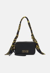 Borsa a tracolla in pelle nera con forma rettangolare, decorata con una tracolla in tessuto a fantasia e dettagli con logo dorato "Versace Jeans Couture".