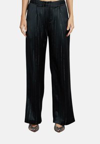 Zwarte wijde broek met streepjes, taillering, plooien en een gladde textuur voor een slanke look. Draagt gecombineerd met zwarte open-toed schoenen.