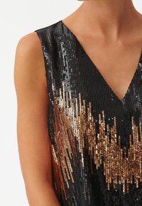 Zwart pailletten top met een V-hals ontwerp. Kenmerkt een gradient van koper- en bronspailletten die een schitterend effect creëren.