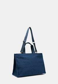 Tumesinist värvi kandekott tekstuurse kangaga, millel on reljeefne logo. Kaks sangad koos reguleeritava rihmaga õlale kandmiseks. Struktureeritud disain, avar sisu.