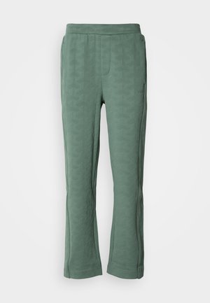 Pantalones verdes con un patrón geométrico texturizado, que cuentan con una cinturilla elástica y un ligero corte acampanado en la parte inferior.