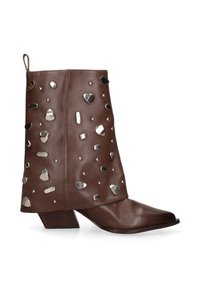 Bruine leren enkelboot met een stevige lage hak en verspreid metalen zilveren studs op de schacht.
