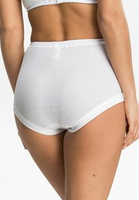 Weiße Baumwoll-Hüfthosen mit hoher Taille und glatter Textur, mit einem breiten Bund und schlichten Design, von hinten sichtbar.