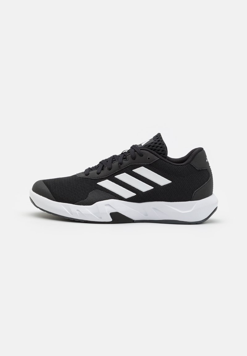 Black athletic shoes with a textured mesh upper, white accent stripes, a cushioned sole, and a reinforced heel for support.