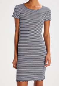 Czarna i biała sukienka w paski z krótkimi rękawami, okrągłym dekoltem i falbaniastym wykończeniem. Wykonana z miękkiego materiału o dopasowanym kroju.