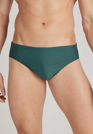 Herren-Schwimmunterhosen in dunklem Blaugrün; hergestellt aus glattem, elastischem Stoff. Verfügt über einen niedrigen Schnitt und minimalen Nähten für ein stromlinienförmiges Erscheinungsbild.