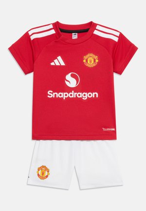 Red Manchester United soccer jersey with white Adidas stripes and logo, Snapdragon sponsor, paired with white shorts featuring the team crest.
