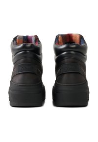 Czarne skórzane botki za kostkę z wyściełanym kołnierzem, z kolorowym, wzorzystym wnętrzem oraz czarnym logo na boku. Gruba podeszwa.