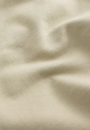 Tejido elástico beige con una textura suave y lisa, y un patrón de costillas fino, que presenta un ligero ondulado en la superficie.