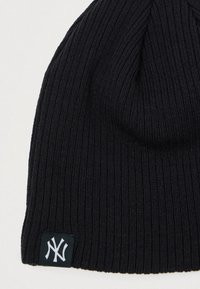 Μαύρο καπέλο από ριπ πλέξη με διπλωμένη άκρη και λευκή λογότυπο επικάλυψη σε πράσινο φόντο στη βάση. Μαλακή υφή και εφαρμοστό σχέδιο.