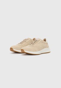 Beige Wildleder-Sneaker mit strukturierter Oberfläche, ausgestattet mit Schnürdesign, weißer Zwischensohle und braunem Gummiaußensohle für Grip und Unterstützung.