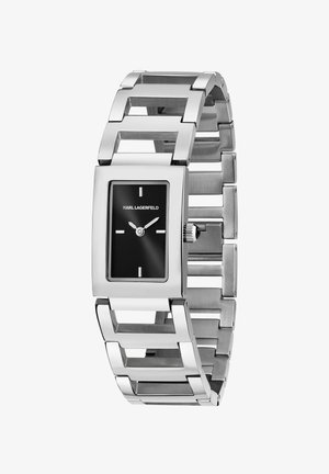 Orologio da polso in metallo argentato con quadrante rettangolare nero, indicatori delle ore bianchi minimalisti e design del bracciale a maglie geometriche.