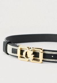 Curea din piele neagră și material crem texturat, cu o dublă cataramă aurie ce prezintă un accent circular și mai multe găuri de reglare.