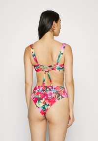 Bikini s kvetinovým vzorom v živých farbách ako ružová a zelená, so širokými ramienkami a viazaním vzadu. Vysoký pás nohavičiek pre lepšie zakrytie.