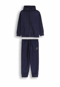 Granatowa bluza z kapturem i suwakiem z przodu, wyposażona w przednią kieszeń, zestawiona z pasującymi dresami z elastycznym paskiem w talii i logo na nogawce.
