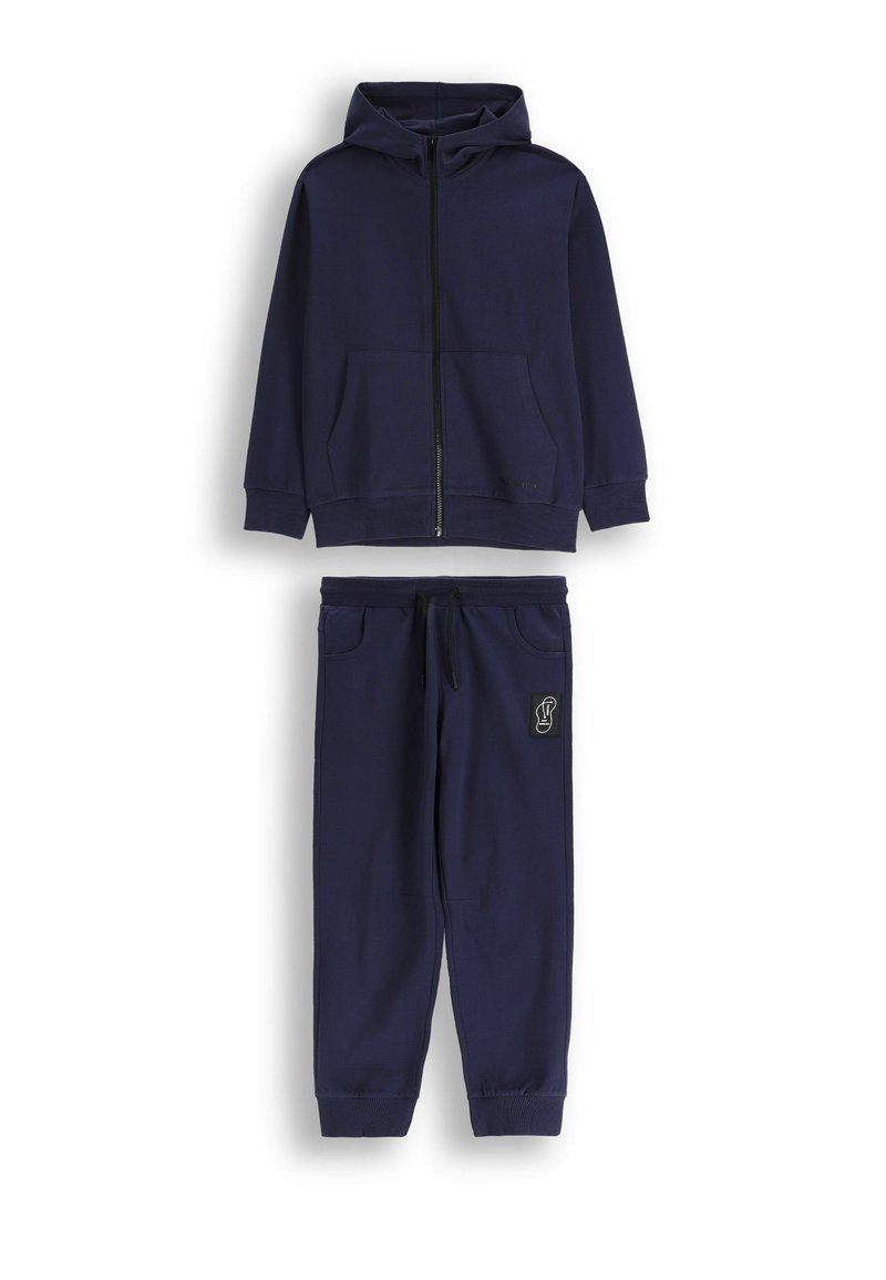 Granatowa bluza z kapturem i suwakiem z przodu, wyposażona w przednią kieszeń, zestawiona z pasującymi dresami z elastycznym paskiem w talii i logo na nogawce.