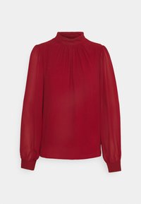 Blouse rouge en tissu léger avec de longues manches bouffantes, un col haut et des plis subtils le long de l'encolure.