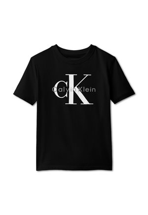 Μαύρο κοντομάνικο μπλουζάκι με μεγάλες λευκές γράμματα "cK" και μικρότερο γκρίζο κείμενο "Calvin Klein" στο στήθος.