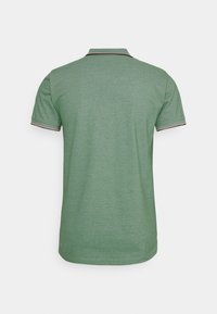 Grønn polo skjorte med strukturert stoff, korte ermer og en kontrastkrage med svarte og røde detaljer. Vist fra baksiden.