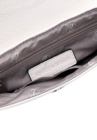 Interior de un bolso de cuero sintético blanco con un bolsillo con cremallera y una etiqueta que dice "Emily & Noa". Forrado con un suave tejido gris y un sutil branding.