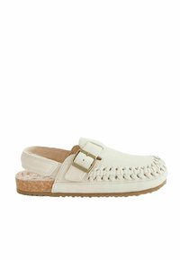 Sabot en suède beige clair avec un design tissé à l'avant, une sangle réglable à boucle et une semelle en liège sur une semelle en caoutchouc texturée.