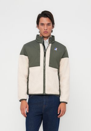 Green and cream fleece jacket with stand-up collar, front zip, chest logo, and contrasting panels. Soft texture with long sleeves.