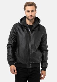 Schwarze Lederjacke mit Reißverschluss vorne, grauer Kapuze und gerippten Bündchen. Verfügt über eine glatte Außenfläche und ein weiches Innenfutter für Wärme.
