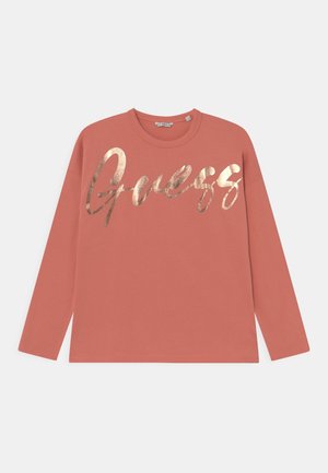 Koralfarvet sweatshirt med lange ærmer og metallisk gyldent kursivt "Guess" logo på brystet samt rund halsudskæring.