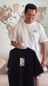 Sort kortærmet t-shirt med et tekstureret, cremfarget grafisk design med bølger på forsiden. Bomuldsmateriale, afslappet pasform.