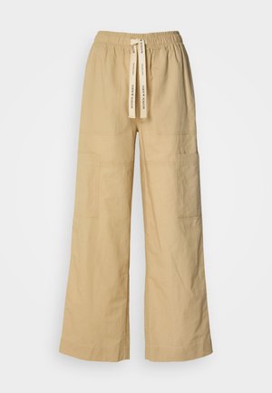 Beige weite Hosen aus weichem Stoff, mit einem elastischen Bund und Kordelzug, seitlichen Taschen und einer lässigen Passform.