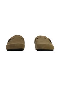 Scarpe slip-on in suede marrone con suola piatta in gomma nera e design minimalista, caratterizzate da due cinturini decorativi sulla parte superiore.