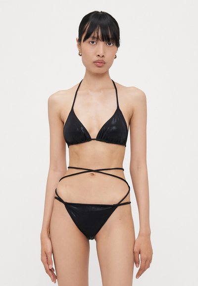 Crni bikini set s trokutastim vrhom i ukrštenim trakama. Materijal je gladak, ističući minimalistički dizajn.