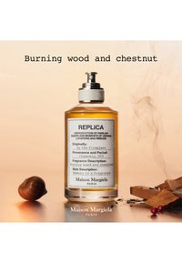 Läpinäkyvä hajuvesipullo, jossa Replica-etiketti Maison Margielalta, kastanjan ja palavien puuelementtien ympärillä vaalealla taustalla.