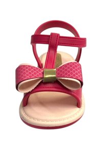 Sandal rosa con un dettaglio a fiocco testurizzato, cinturini regolabili e suola beige. Presenta un accento dorato al centro del fiocco.