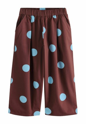 Locker sitzende braune Hose mit großen hellblauen Polka-Dots und einem elastischen Bund mit seitlichen Taschen.
