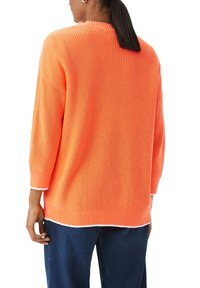 Übergroßer orangefarbener Strickpullover mit gerippter Textur, weiten Ärmeln und kontrastierendem weißen Saum. Sichtbares Rückendetail und lockere Passform.