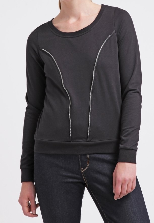 Svart sweatshirt med långa ärmar, med en distinkt dragkedja längs fram. Mjukt tyg och ribbade ärmmuddar och nederkant.