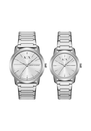 Zwei silberne Armani Exchange Armbanduhren mit Metallgliederbändern, runden Zifferblättern und minimalistischen Stundenmarkierungen nebeneinander auf weißem Hintergrund.