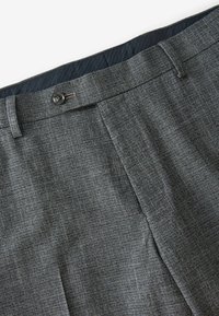 Grau gemusterte Hose aus strukturiertem Stoff, mit flachem Frontschnitt, einem Knopfverschluss und einem marineblauen Innenfutter.