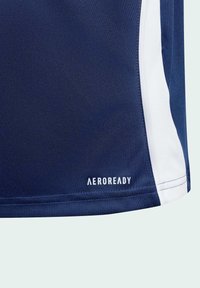 Marineblått elastiskt tyg med vit sidopanel och "AEROREADY"-logotyp tryckt nära fållen.