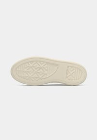 Beige shoe sole with diamond and line tread patterns and "Converse All Star" logo embossed near the ball of the foot.