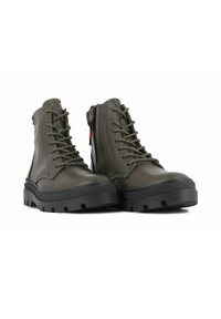 Botas de tobillo de cuero verde con un diseño alto, parte delantera con cordones, cremallera lateral y suela de goma negra con tacos profundos para mayor agarre.