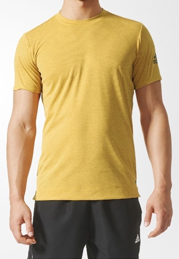 Camiseta atlética amarilla de manga corta con un patrón texturizado, que presenta un escote redondo y un logotipo negro en el hombro izquierdo.