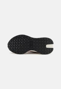Nike shoe outsole, featuring a black rubber material with textured squares and diamonds for traction, marked with "NIKE" logo in the center.