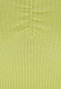 Rippstrickstoff in leuchtendem Limettengrün; mit vertikalen Streifen und einer glatten Textur, dazu subtile Falten in der Mitte.