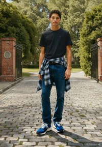 Modelis dėvi juodą marškinėlį, mėlynas džinsus ir mėlynus sportinius batelius. Patikra palaidinė, surišta aplink juosmenį, suteikia kontrastingą raštą.